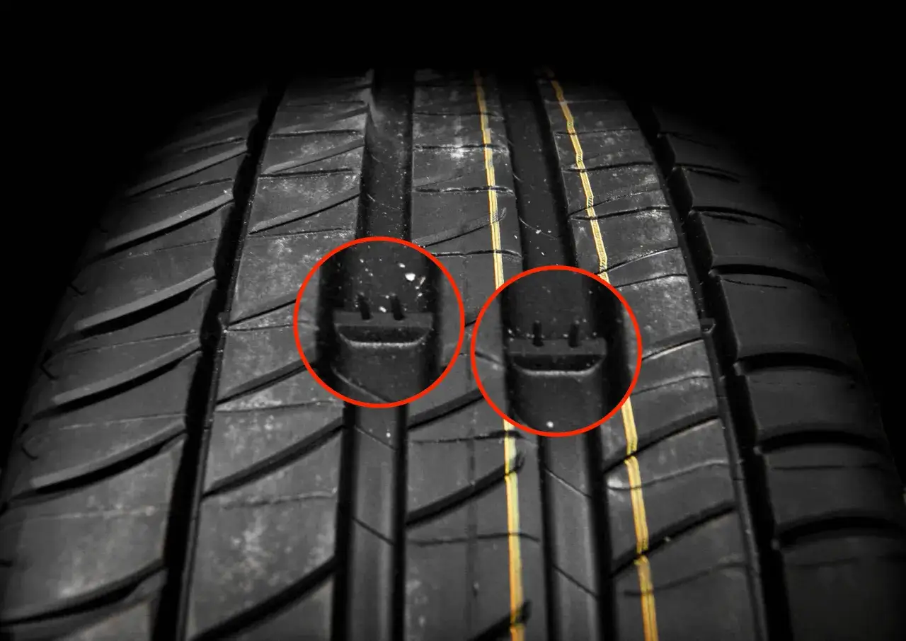 Gros plan sur un pneu hiver. Les cercles rouges mettent en &eacute;vidence les indicateurs d'usure, essentiels pour conna&icirc;tre la date de fabrication et l'&eacute;tat du pneu.