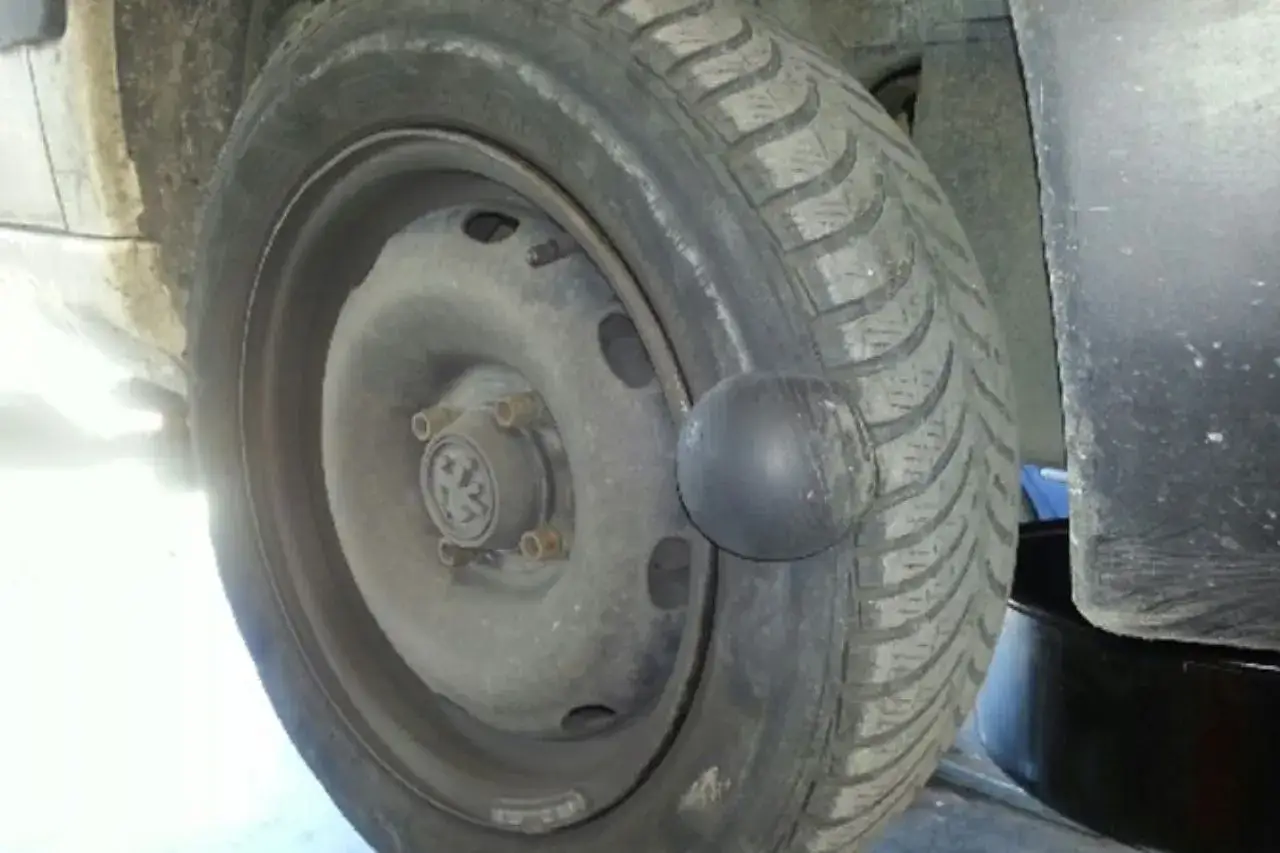 Gros gonflement sur un pneu de voiture, une boule noire est sortie du flanc.