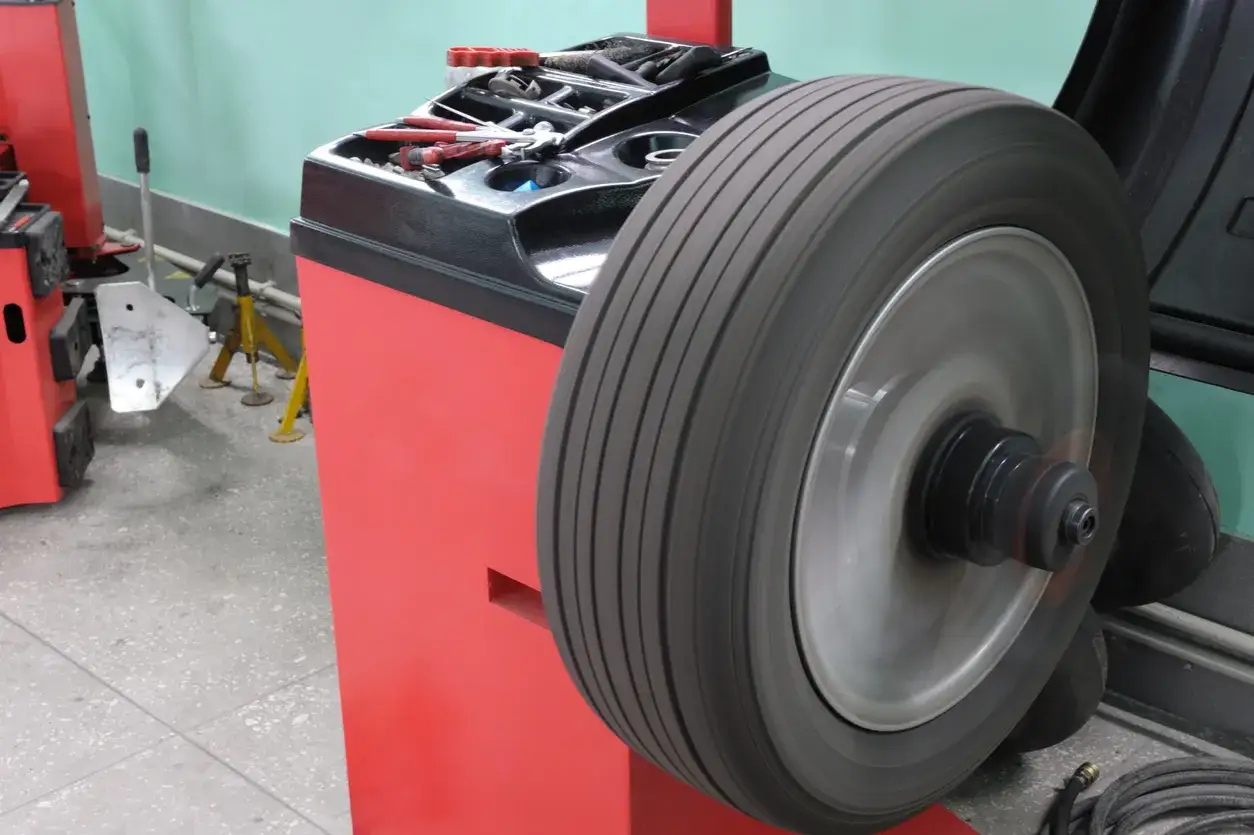 Un pneu tourne sur une machine d'équilibrage, un outil essentiel pour l'équilibrage des pneus.