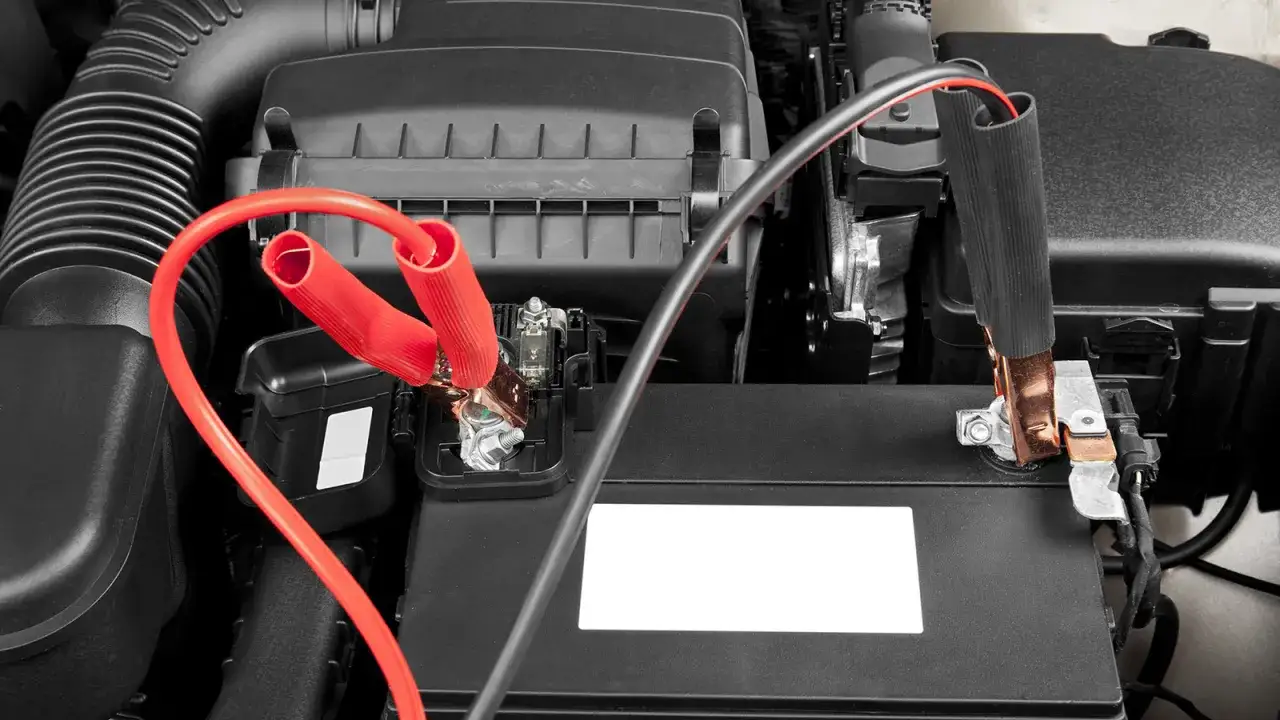 Câbles de démarrage connectés à une batterie de voiture. Apprenez comment recharger une batterie de voiture sans rien d'autre que ces câbles.