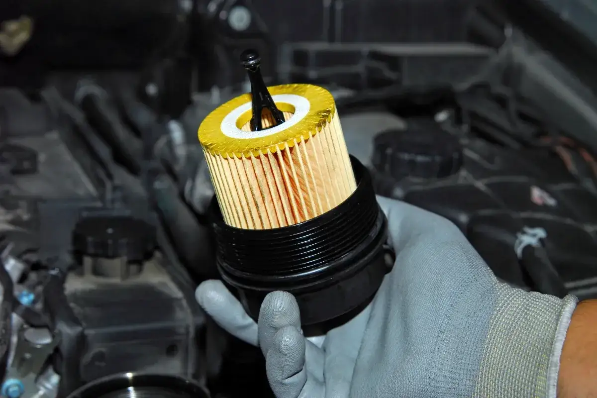 Main d'un m&eacute;canicien tenant un filtre &agrave; huile neuf pour BMW. Un sympt&ocirc;me de reniflard d'huile bouch&eacute; peut &ecirc;tre li&eacute; &agrave; un filtre encrass&eacute;.
