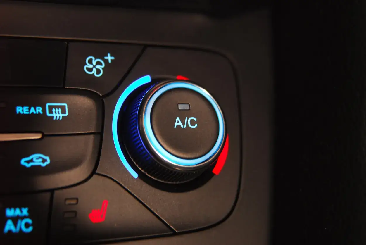 Bouton de climatisation de voiture avec voyant bleu lumineux. Le r&eacute;glage A/C est activ&eacute;.