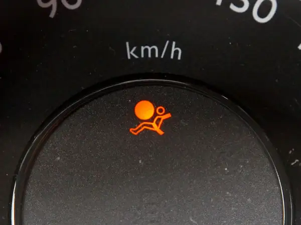 Voyant airbag qui clignote sur un tableau de bord Nissan, signalant un problème potentiel avec le système de sécurité.