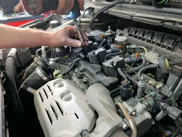 Mécanicien remplaçant une bougie d'allumage pour optimiser la durée de vie de la bougie d'allumage. Moteur de voiture détaillé.