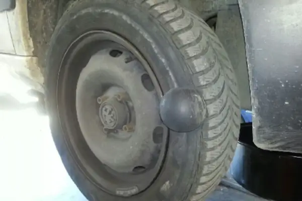 Gros gonflement sur un pneu de voiture, ressemblant à une boule noire.