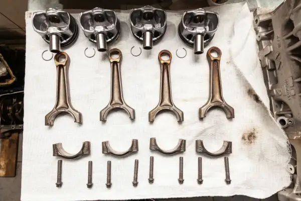 Pièces d'un moteur : pistons, bielles, chapeaux de bielle et vis. Prêt à réparer un moteur qui a eu un problème de couler une bielle.