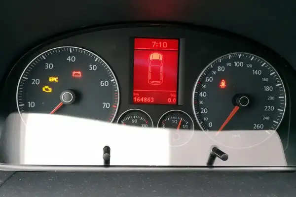 Tableau de bord d'une voiture avec voyant EPC allumé, témoin de batterie et de ceinture de sécurité. Kilométrage : 164863 km.