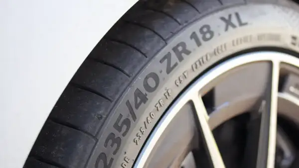 Gros plan sur un pneu de voiture avec l'inscription "235/40 ZR 18 XL". Le "XL" indique une capacité de charge accrue, ce qui répond à la question "pneu XL c'est quoi".
