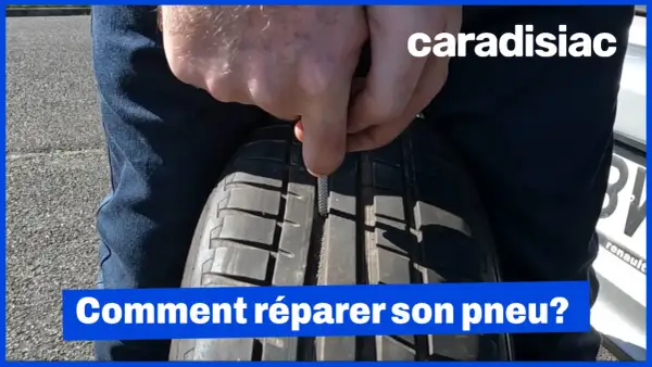Un homme utilise un outil pour insérer une mèche dans un pneu. La réparation pneu mèche est interdite sur le flanc.