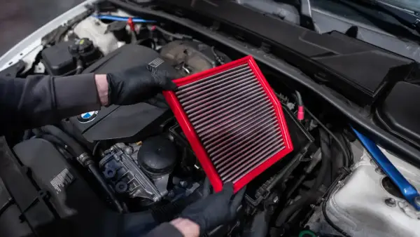 Maintenant, je vais nettoyer le filtre à air de la voiture. Il est rouge et rectangulaire.