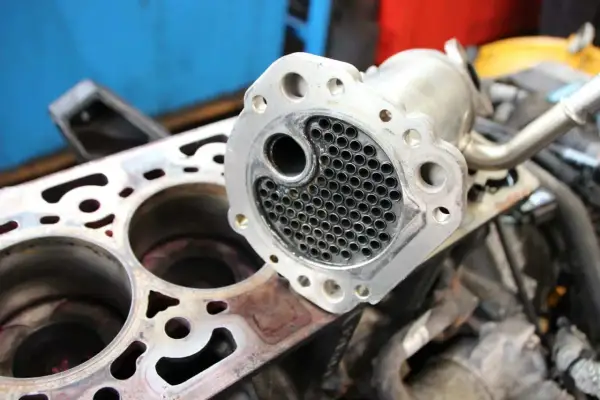 Refroidisseur EGR démonté, prêt pour réparation. Un symptôme refroidisseur EGR HS peut causer des problèmes de performance moteur.